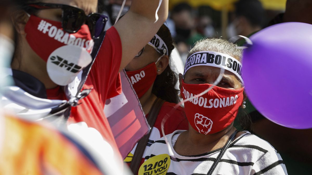 معارضة برازيلية تلبس قناعاً كتب عليه "بولسونارو خارجاً" 