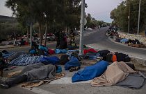 In this Thursday, Sept. 10, 2020, file photo, refugees and migrants sleep on a street near the destroyed Moria camp following a fire, on Lesbos island, Greece.