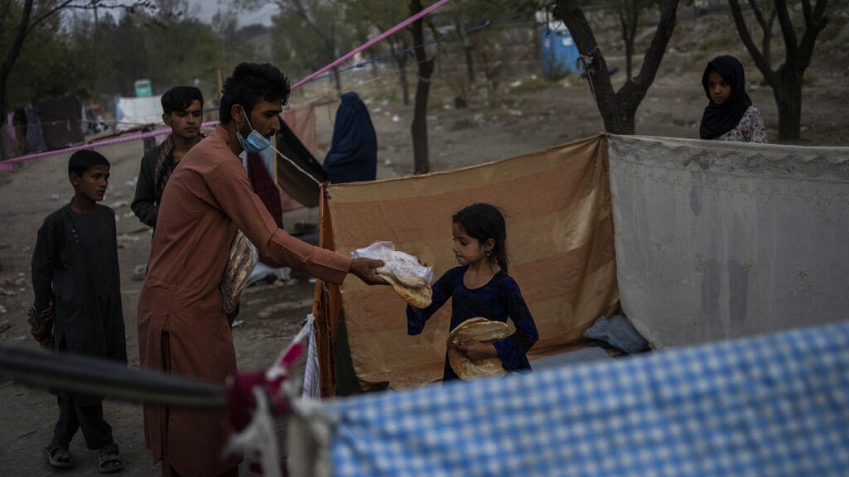 Displaced Afghans distribute food donations at an internally displaced persons camp in Kabul, Afghanistan, Monday, Sept. 13, 2021. 