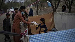 Displaced Afghans distribute food donations at an internally displaced persons camp in Kabul, Afghanistan, Monday, Sept. 13, 2021. 