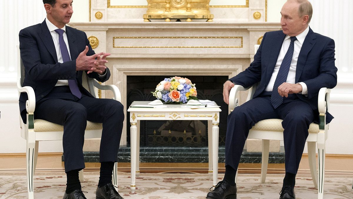 Russian President Vladimir Putin, right, sits with Syrian President Bashar Assad