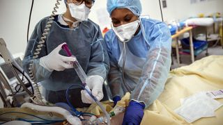 Nurses care for a patient inside an operating room now used for unconscious COVID-19 patients at Bichat Hospital, AP-HP, in Paris, April 22, 2021.