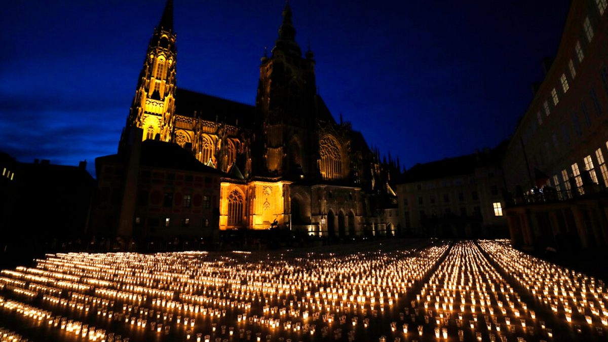 Candles are lit to commemorate victims of the COVD-19 pandemic at the Prague Castle in Prague, Czech Republic, Monday, May 10, 2021