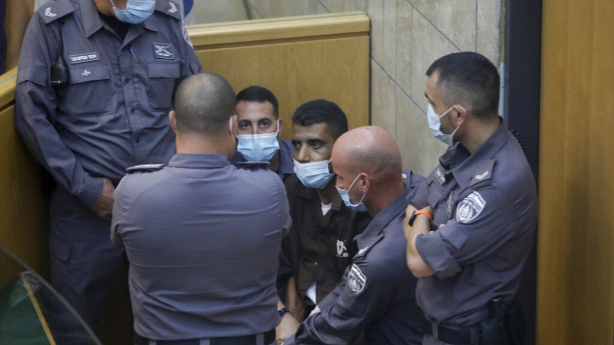 زكريا الزبيدي، أحد الفلسطينيين الستة الذين فروا من سجن جلبوع، محاط بالحراس في قاعة محكمة في مدينة الناصرة بإسرائيل، يوم السبت 11 سبتمبر 2021