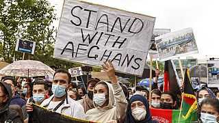A woman holds a sign reading "Stand with Afghans" during a demonstration for the reception of threatened people from Afghanistan, in Hamburg, Germany, Sunday Aug. 22, 2021.