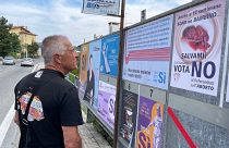Житель Сан-Марино рассматривает афиши сторонников и противников абортов, 10 сентября 2021 г.