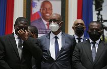 Haiti's Prime Minister Ariel Henry (C) in front of a portrait of slain Haitian President Jovenel Moise at the National Pantheon Museum Port-au-Prince, Haiti, July 20, 2021.