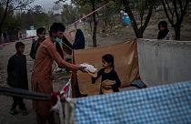 Displaced Afghans distribute food donations at an internally displaced persons camp in Kabul, Afghanistan, Monday, Sept. 13, 2021.