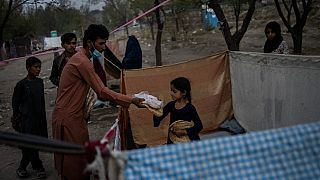Displaced Afghans distribute food donations at an internally displaced persons camp in Kabul, Afghanistan, Monday, Sept. 13, 2021.
