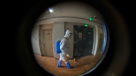 A medical worker wearing a protective clothing disinfectants a corridor of a hotel used for foreigners to stay during a period of health quarantine