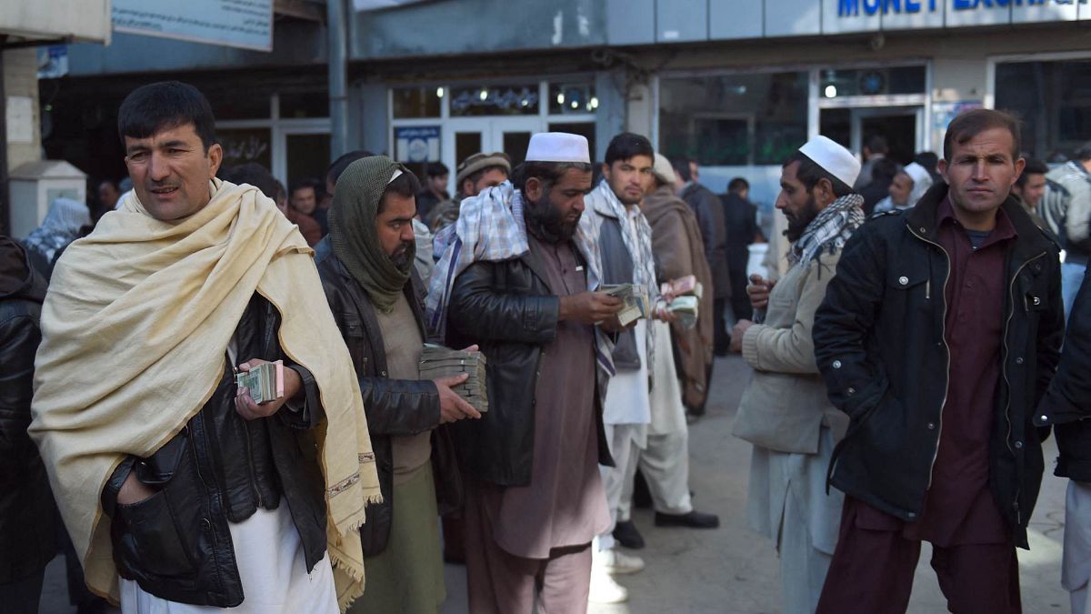صرافون أفغان ينتظرون العملاء في سوق صرف العملات في كابول، أفغانستان، 17 ديسمبر 2015