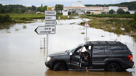 A driver looks at the water flooding a road in Aigues, in the Gard department, in the Occitanie region, southern France, on September 14, 2021 following heavy rains.