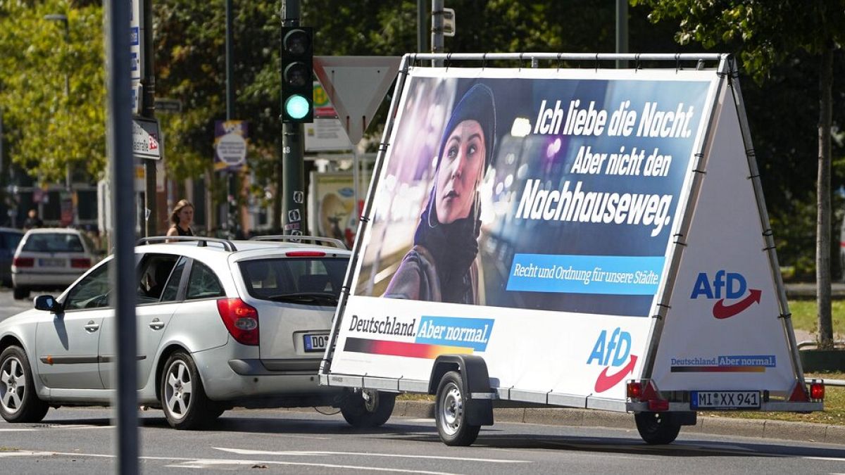 In this Wednesday, Aug. 25, 2021 file photo a car pulls an election poster for the right wing party 'Alternative for Germany' (AfD) at a street in Duesseldorf, Germany.