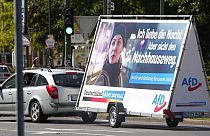 In this Wednesday, Aug. 25, 2021 file photo a car pulls an election poster for the right wing party 'Alternative for Germany' (AfD) at a street in Duesseldorf, Germany.