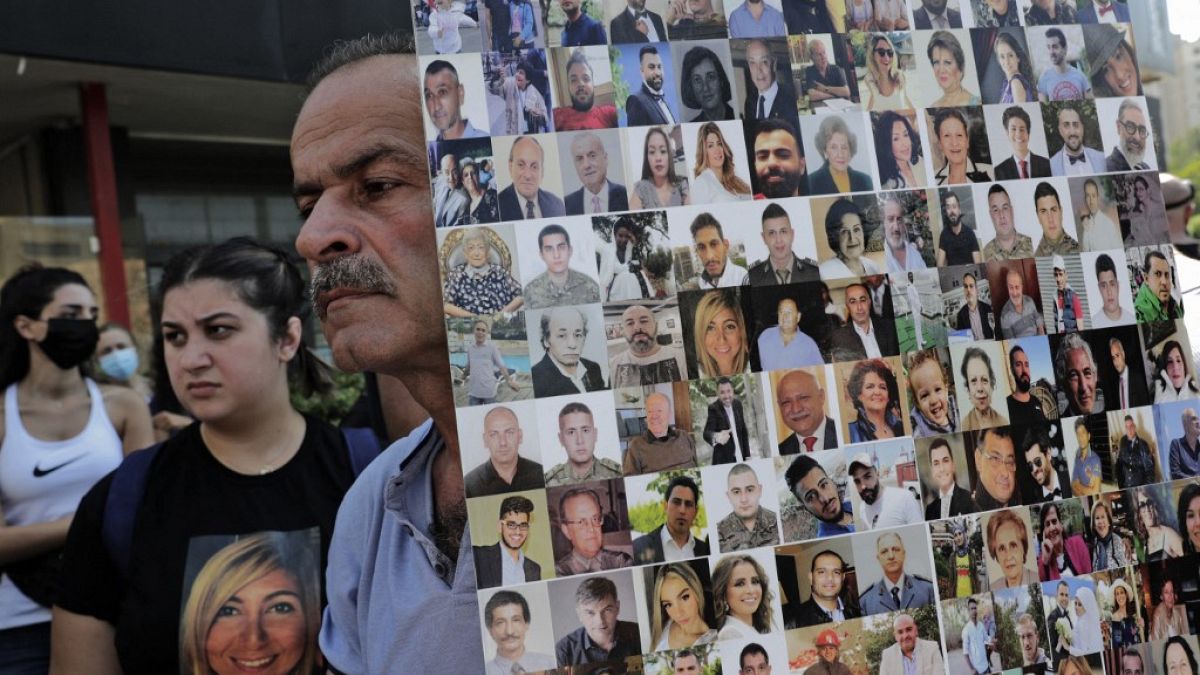لافتة تظهر وجوه ضحايا انفجار مرفأ بيروت بينما تجمع محتجون وأفراد عائلات الضحايا في مظاهرة بالقرب من قصر اليونسكو في بيروت - 12 أغسطس 2021 