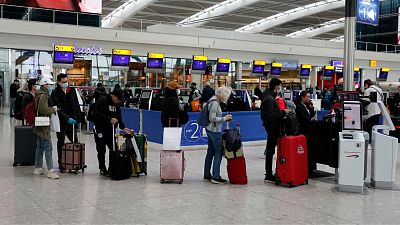 People queue at ticket machines at Heathrow airport in London, Wednesday, March 18, 2020. People queue at ticket machines at Heathrow airport in London, Wednesday, March 18, 2020.
