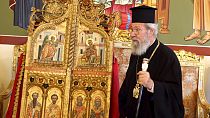 The leader of Cyprus Orthodox Church, Archbishop Chrysostomos II, stands next to the reclaimed doors at the Archbishopric in Nicosia on Thursday