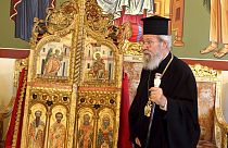 The leader of Cyprus Orthodox Church, Archbishop Chrysostomos II, stands next to the reclaimed doors at the Archbishopric in Nicosia on Thursday