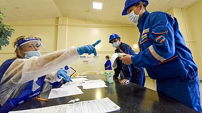 Employees get their ballots during early voting at the Mutnovskaya geothermal power plant in the Elizovsky district in Russia's Far East on Thursday Employees get their ballots during early voting at the Mutnovskaya geothermal power plant in the Elizovsky district in Russia's Far East on Thursday
