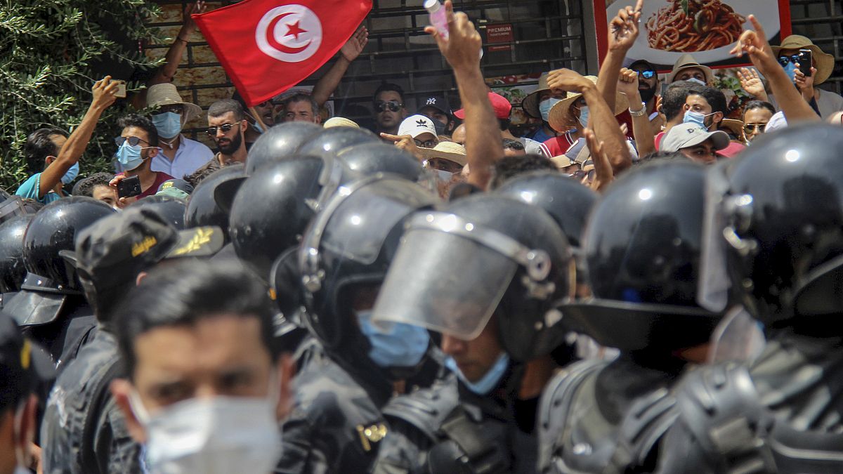 متظاهرون تونسيون يواجهون عناصر الشرطة خلال مظاهرة في تونس العاصمة في 25 تموز/يوليو 2021