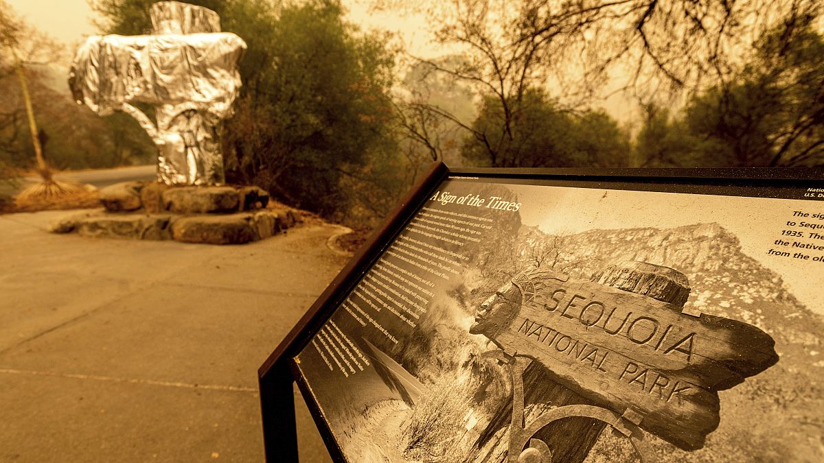 Fire-resistant wrap covers a historic welcome sign as the KNP Complex Fire burns in Sequoia National Park, Calif., on Sept. 15, 2021. 