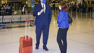 France's Ambassador to Australia Jean-Pierre Thebault talks to an unidentified woman as he arrives at Sydney Airport, Saturday, Sept. 18, 2021.