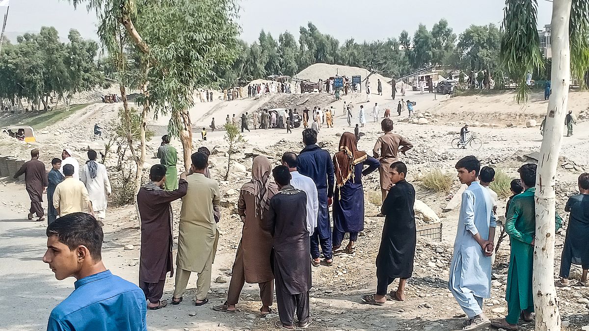عناصر من طالبان ومدنيون يتجمعون في موقع انفجار قنبلة استهدفت شاحنة صغيرة تقل مقاتلي الحركة في جلال آباد في 19 أيلول/سبتمبر 2021