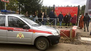 Pessoas e polícia à porta da universidade de Perm após o tiroteio