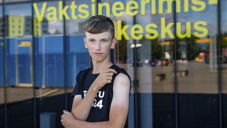 Joonas Leis , 12 years old boy, poses for a photo after getting a shot a coronavirus vaccine at a vaccination center inside a sports hall in Estonia.