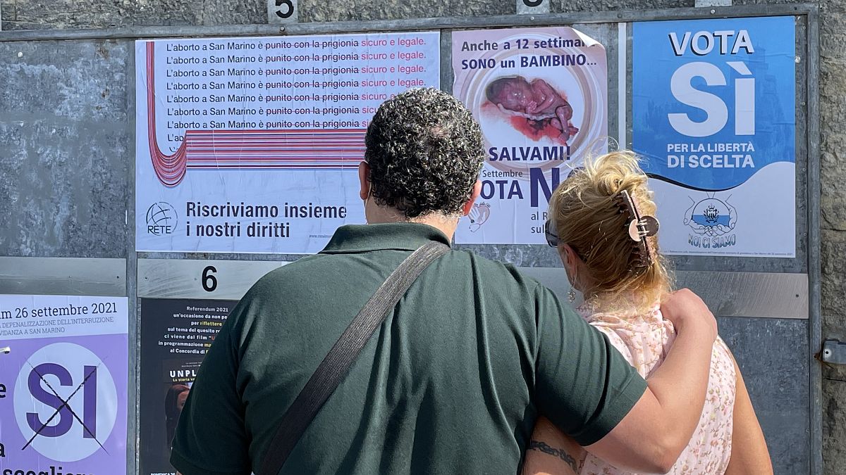 People view pro and anti-abortion campaign posters on September 10, 2021 in San Marino at the start of the referendum campaign