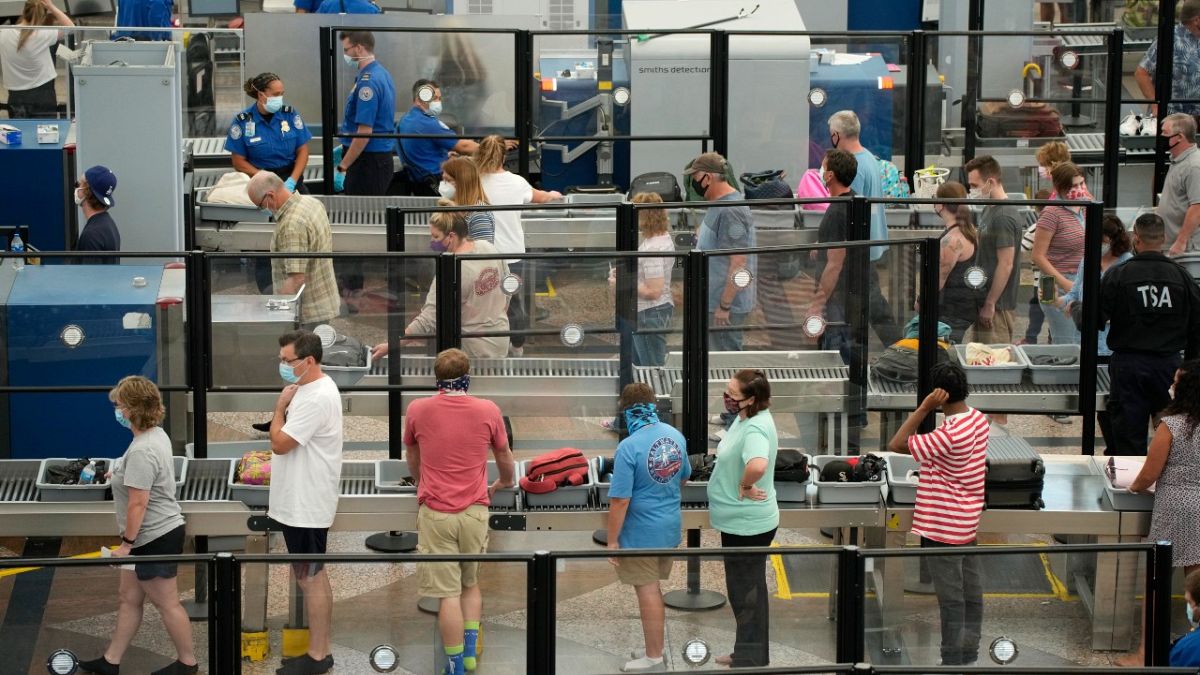 مسافرون يضعون كمامات عند نقطة تفتيش أمنية في مطار دنفر الدولي، 24 أغسطس 2021 