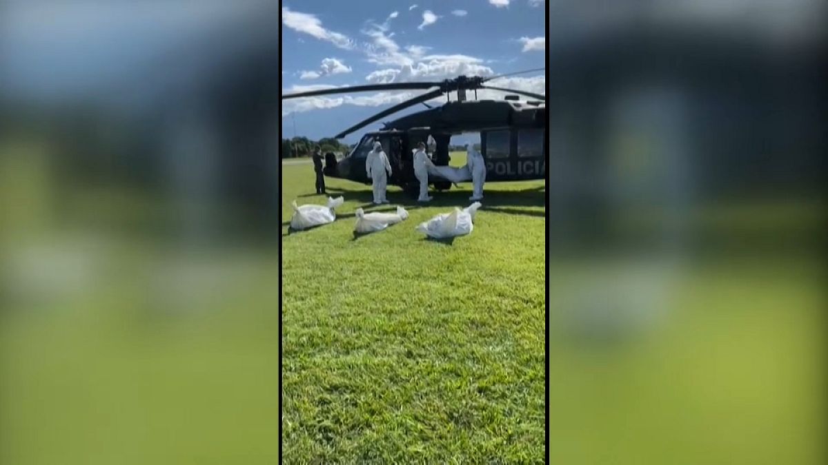 Militares con trajes de protección extraer varios cadáveres de guerrilleros del ELN de un helicóptero del Ejército colombiano