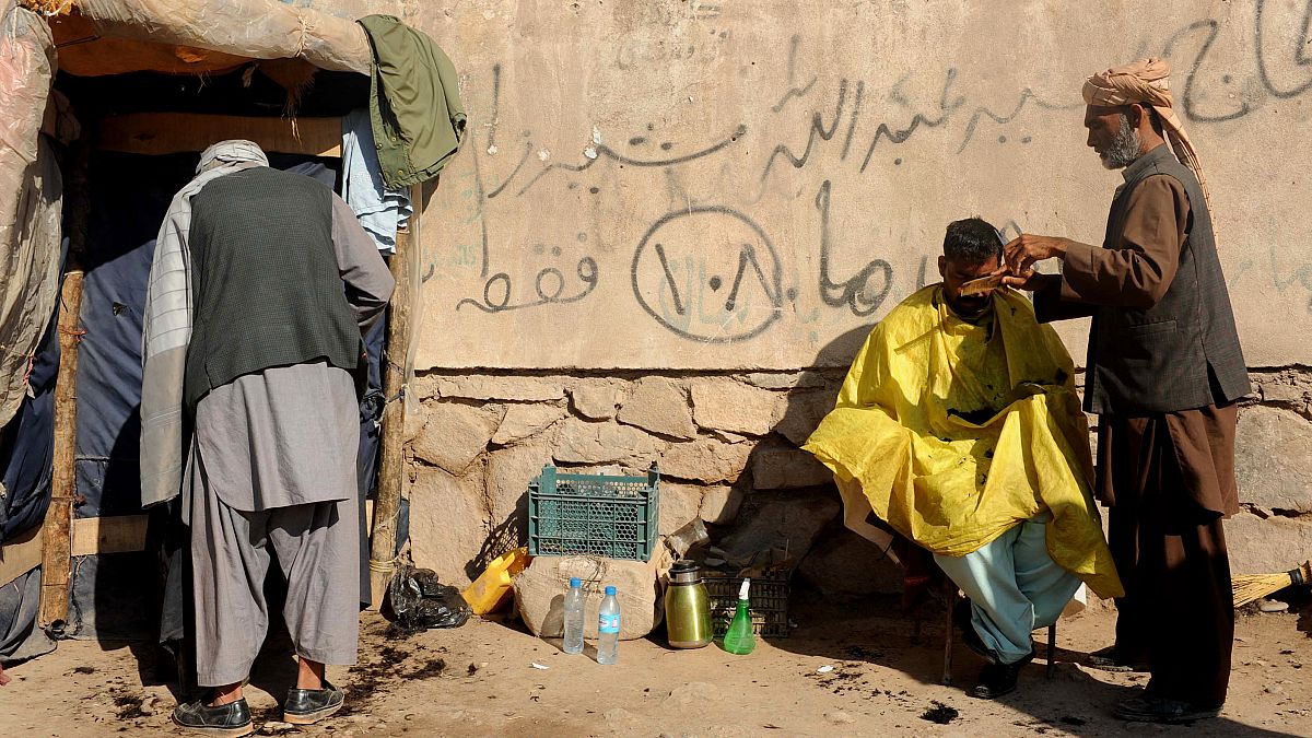 حلاق أفغاني يقص شعر حريف في مدينة هرات. 2013/02/10