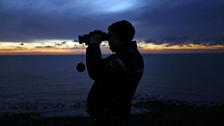 In this file photo dated Friday, Jan. 18, 2019, a French gendarme patrols the beach in Ambleteuse near Calais, northern France