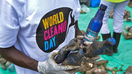 A World Cleanup Day volunteer collects and sorts plastic bottles removed from the River Wigwa in Kisumu, Kenya, Sept. 18, 2021.