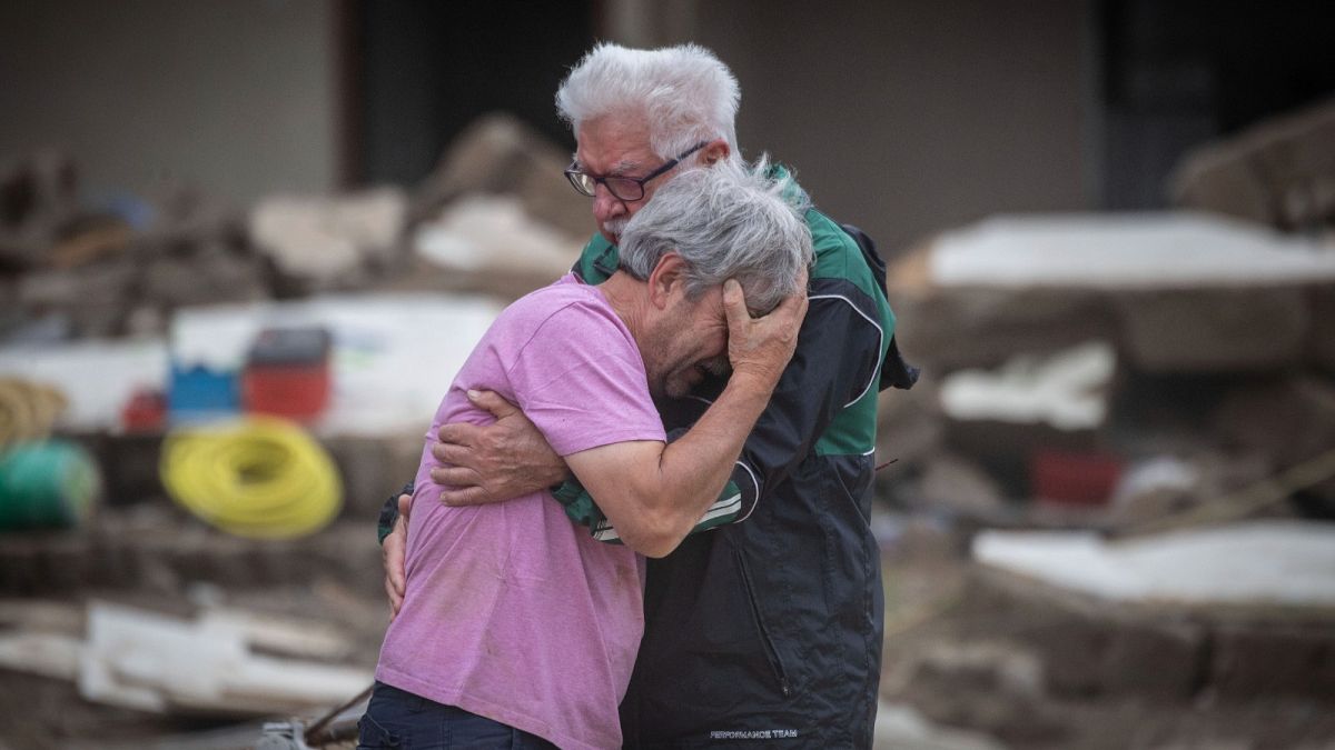 Dos hermanos lloran abrazados frente a la casa de sus padres, destruida por la inundación en Altenahr, Alemania, el lunes 19 de julio de 2021.