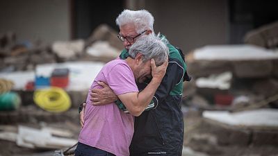 Dos hermanos lloran abrazados frente a la casa de sus padres, destruida por la inundación en Altenahr, Alemania, el lunes 19 de julio de 2021.