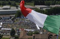 A man waves the Italian flag on a hill during a the traditional League party rally in Pontida in 2018.