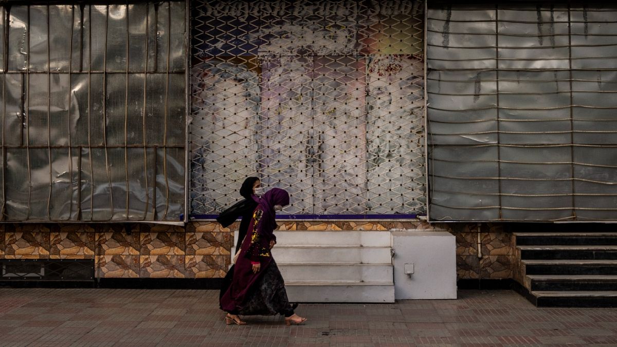 نساء في العاصمة الأفغانية أمام صالون حلاقة نسائي مغلق
