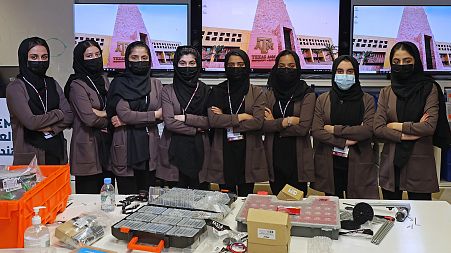 Members of an all-girl Afghan robotics team pose for a picture at the laboratory of Qatar's Texas A&M university in the capital Doha