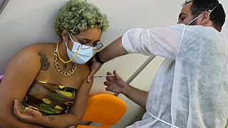 A military nurse inoculates Eduarda, from Brazil, with the Pfizer coronavirus vaccine at a vaccination center in Lisbon, Tuesday, Sept. 21, 2021