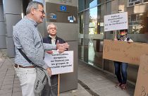 Francia, angol és német nyelvű táblákkal üzenetek a petíció átadásakor Brüsszelnek