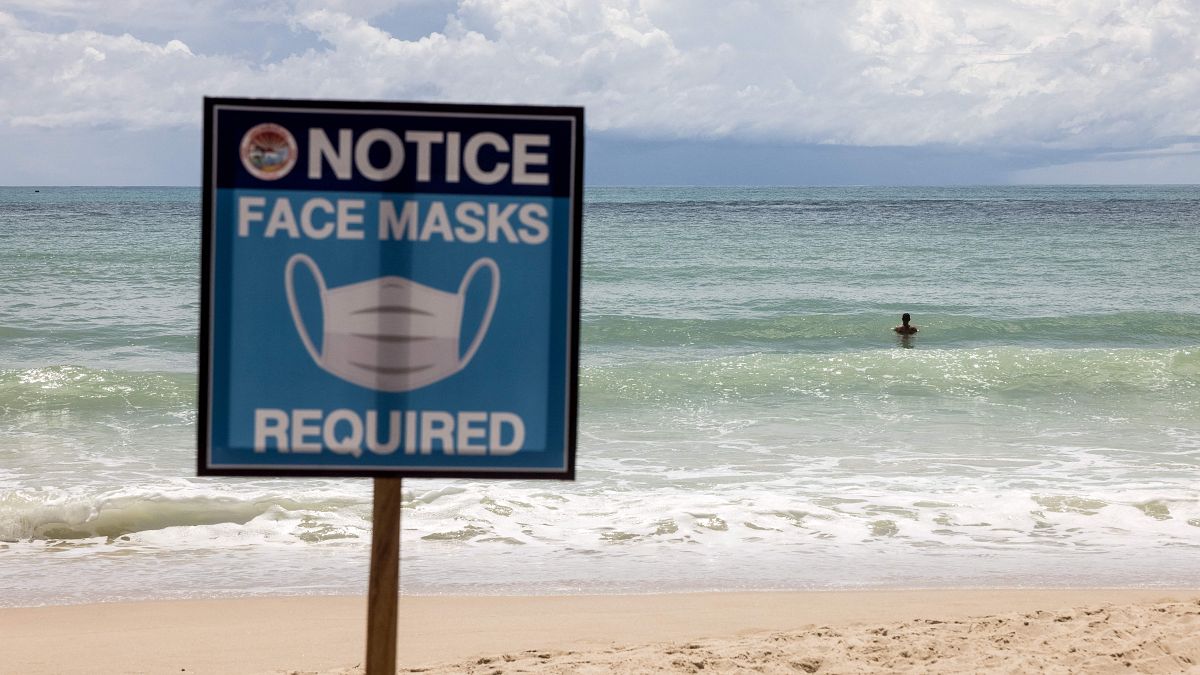 August 14, 2021 shows a sign reading "Face Masks Required" on Patong Beach in Phuket. 