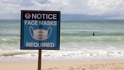 August 14, 2021 shows a sign reading "Face Masks Required" on Patong Beach in Phuket.