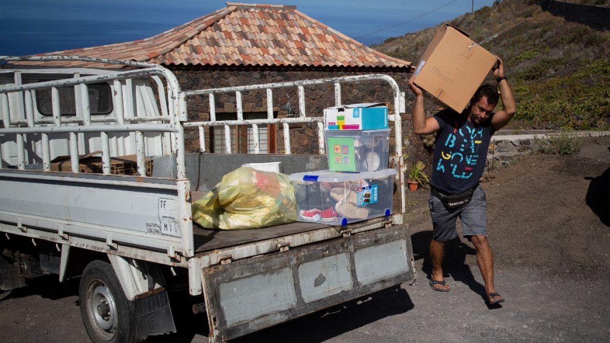 Edrey Concepcion loads his van with the neighbours' belongings as he helps during the evacuation of residents in Tacande due to the volcanic eruption in Cumbre Vieja.
