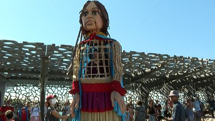 a giant puppet alerts on the fate of migrant children