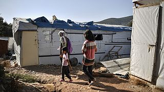 One of the very few remaining families walk in the 'jungle' part of the Samos old Reception and Indentification center in Vathy, on September 19, 2021.