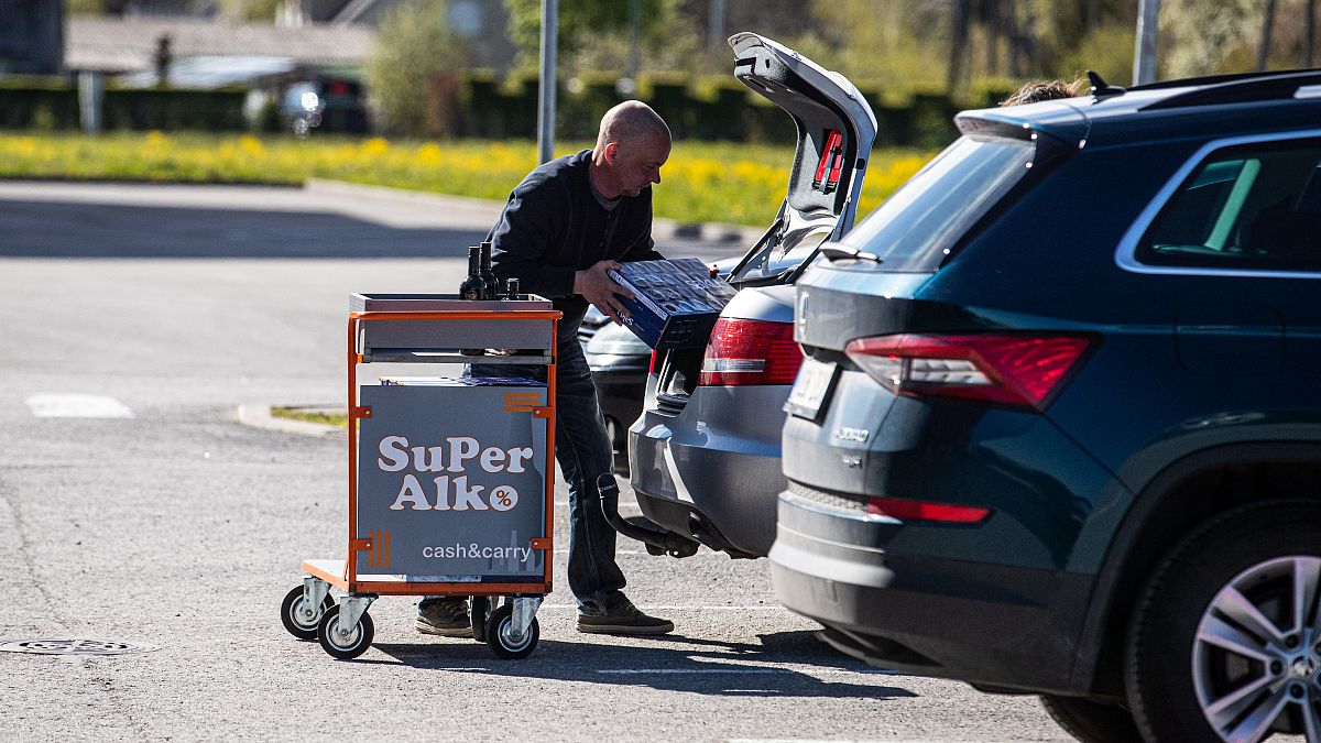 A shopper loads his car at a alcohol shop near the Latvian-Estonian border