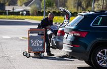 A shopper loads his car at a alcohol shop near the Latvian-Estonian border