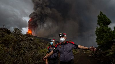A police officer orders journalists to leave the area during a media tour near the volcano on the island of La Palma in the Canaries, Spain, Sept. 22, 2021. 